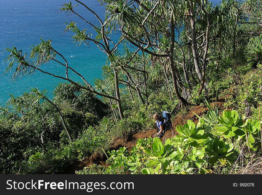 A backpacker hikes along the Na Pali coast on the island of Kaui. A backpacker hikes along the Na Pali coast on the island of Kaui