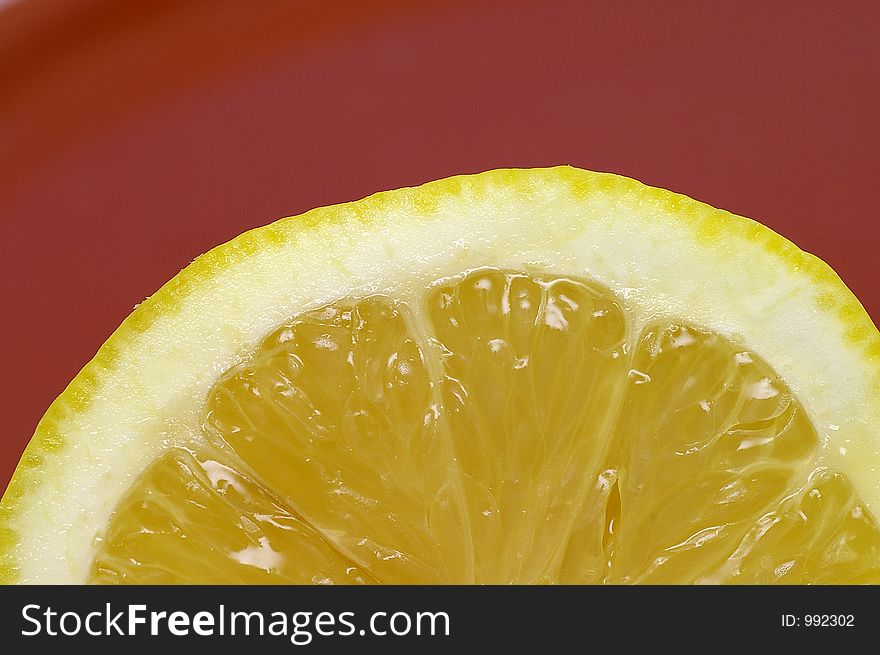 Closeup of a sliced lemon against a brown background. Closeup of a sliced lemon against a brown background