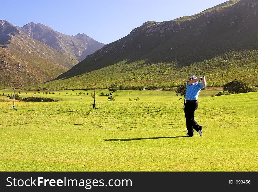 Golfer taking a shot from the fairway.