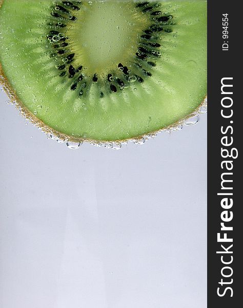 Slice of kiwi dripping with water. Slice of kiwi dripping with water.
