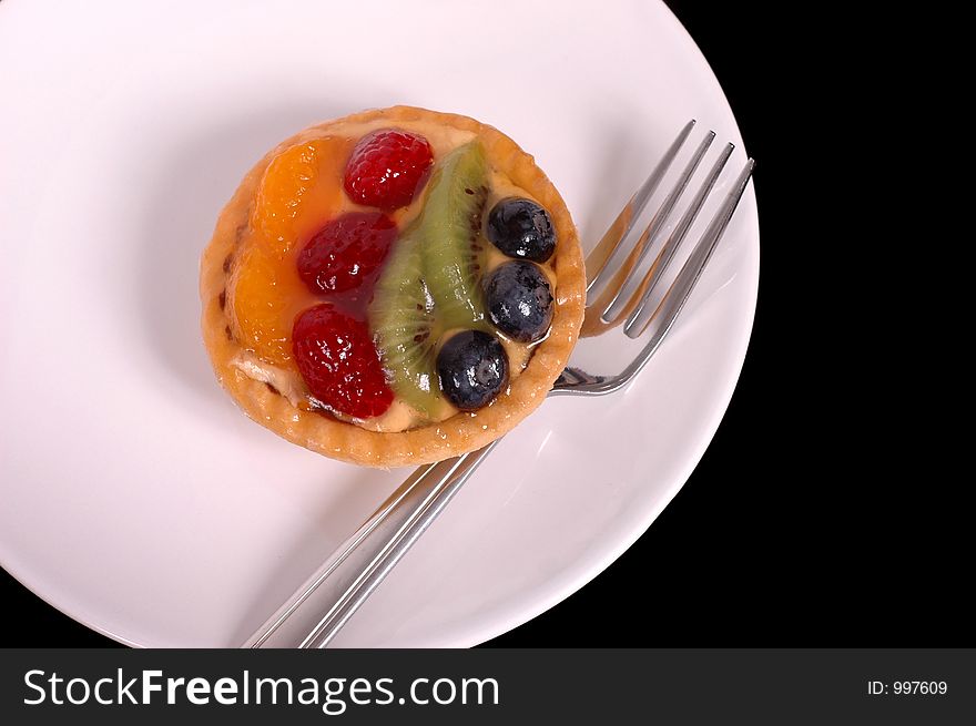 Fruit tart on white plate with fork. Fruit tart on white plate with fork