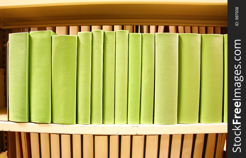 Row of colorful green books with no titles
