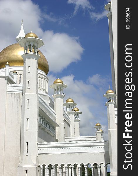 Golden mosque minarets against blue sky & clouds. Golden mosque minarets against blue sky & clouds