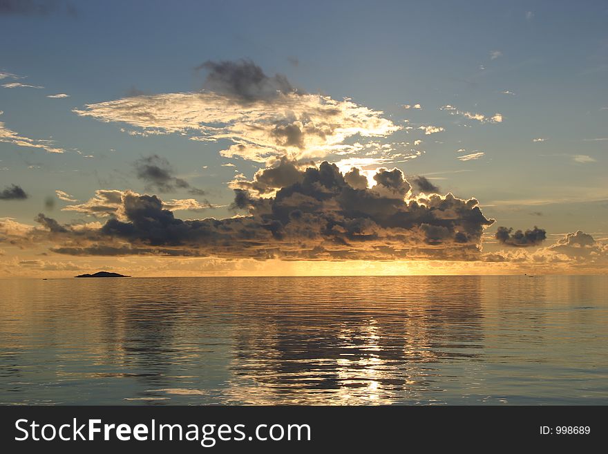 Sunrise behind clouds over sea. Sunrise behind clouds over sea