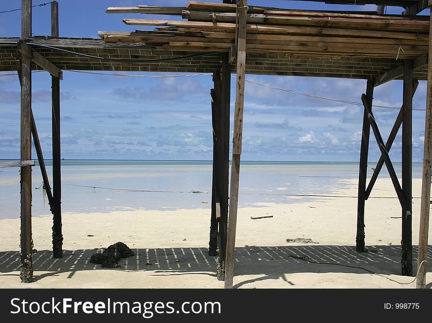 Wood stack on stilts with beach behind. Wood stack on stilts with beach behind