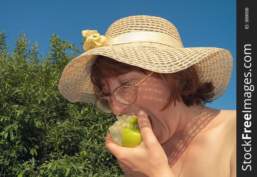 Girl eats apple on nature