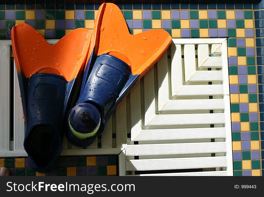 Swim fins on the side of the pool - used for lap swimming. Swim fins on the side of the pool - used for lap swimming