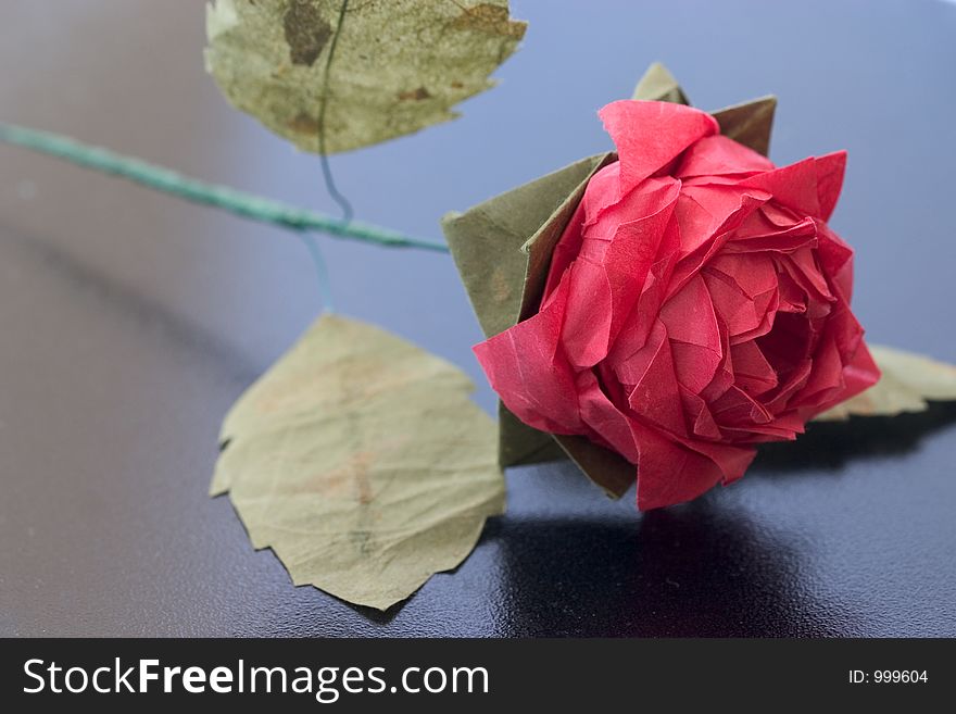 Origami rose on slightly reflective black table. Origami rose on slightly reflective black table