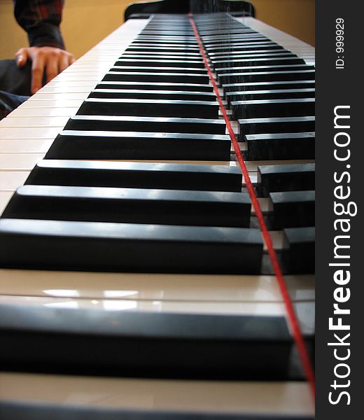 Piano keys and a man ready to play the piano in the background