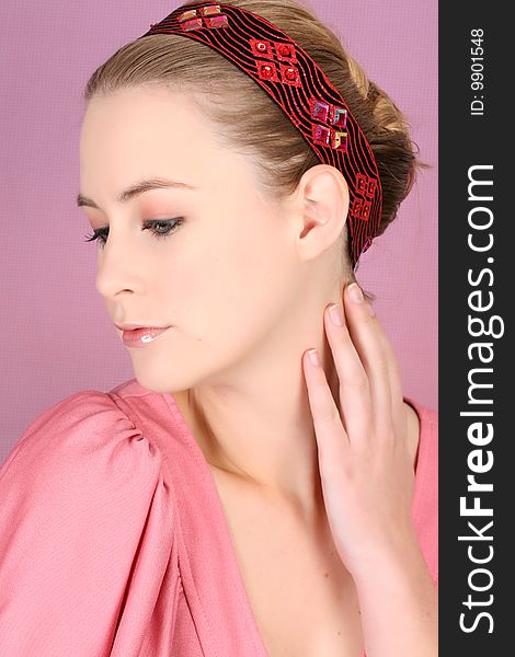 Beautiful blond female model wearing pink dress and hair accessories