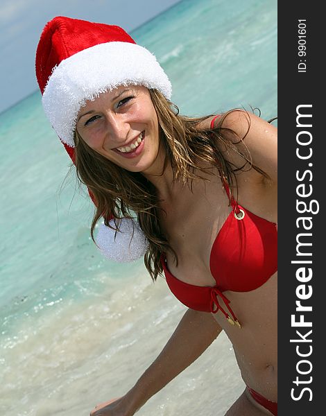 Smiling Woman On The Beach In Santa Hat