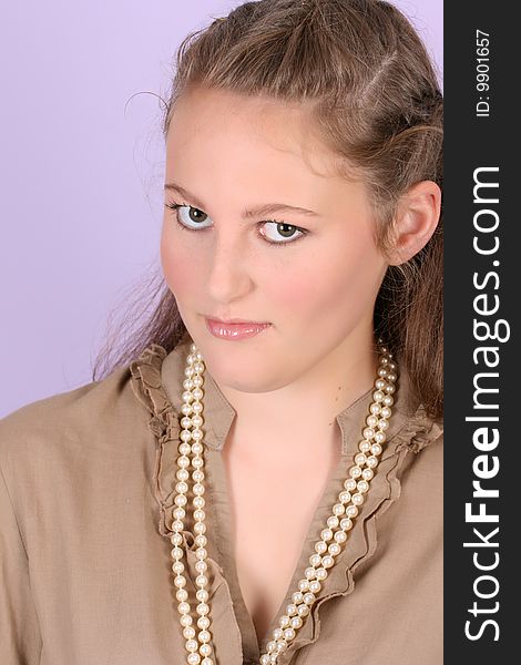 Beautiful teenage female against purple background, wearing pearls. Beautiful teenage female against purple background, wearing pearls
