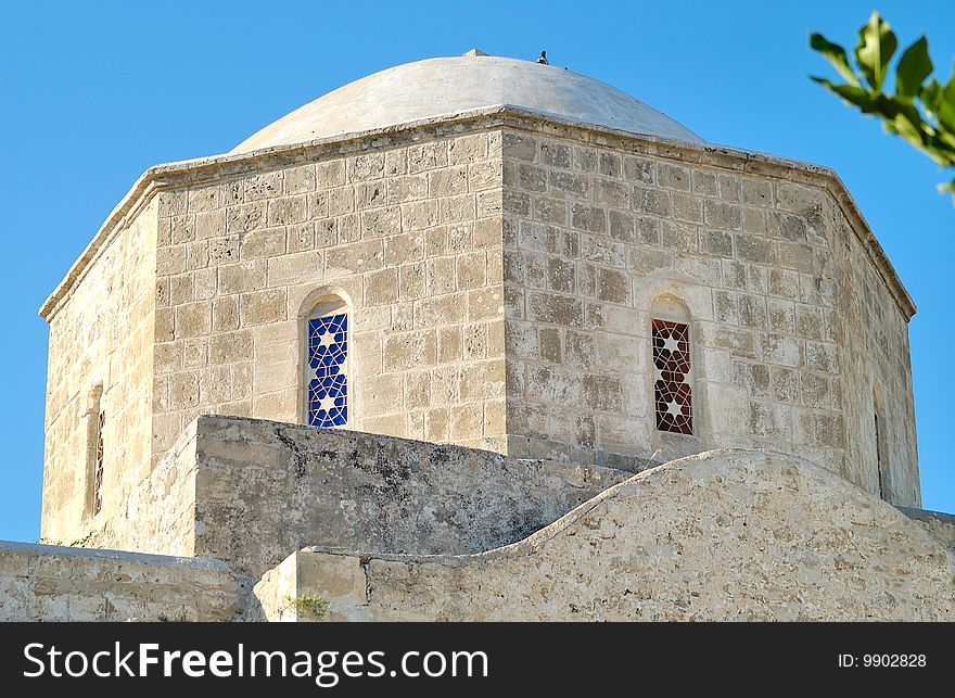 A dome of an ancient church with colored stained-glass windows in Paphos. A dome of an ancient church with colored stained-glass windows in Paphos.