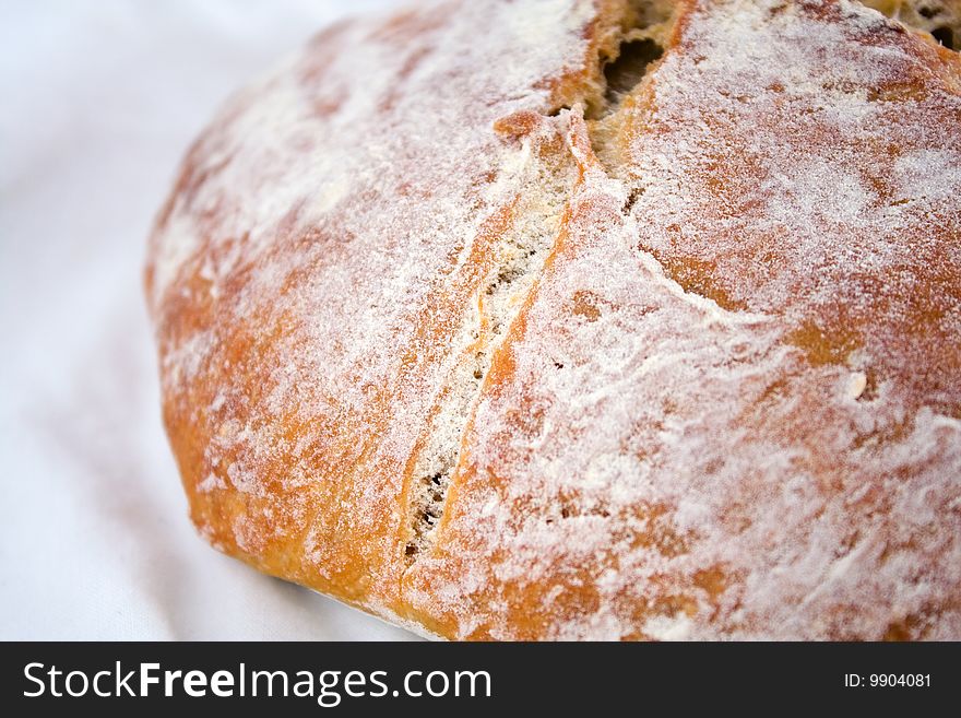 Closeup of fresh-baked whole-wheat bread on a white cotton cloth. Closeup of fresh-baked whole-wheat bread on a white cotton cloth.