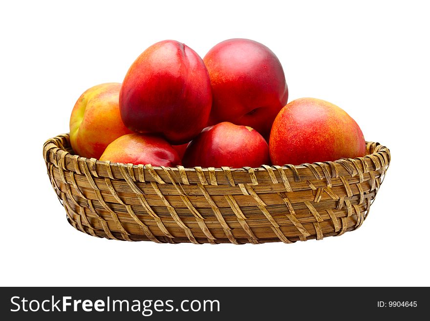 Basket full of fresh peaches isolated on white background