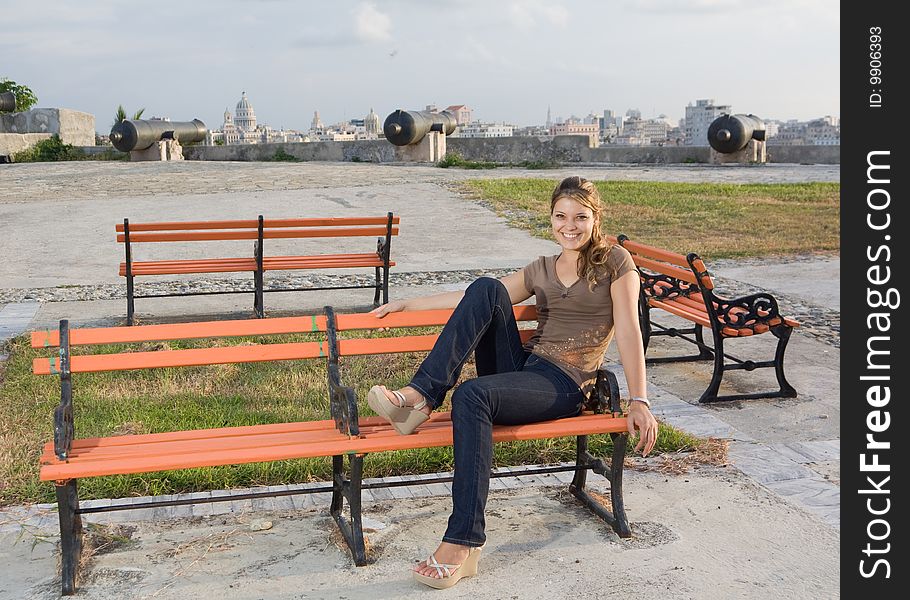 Girl Relaxing In A Orange Coloured Bench