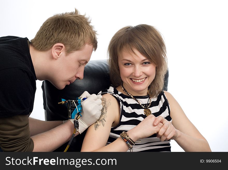 A man drawing tattoo picture on woman's arm. A man drawing tattoo picture on woman's arm