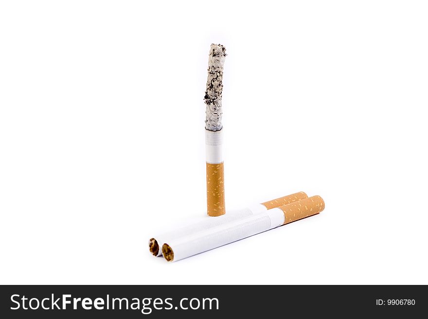 Vertically standing burning cigarette with two cigarettes near. Vertically standing burning cigarette with two cigarettes near