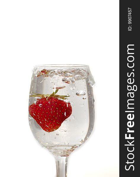Strawberry in the clear water on white background in the glass. Strawberry in the clear water on white background in the glass
