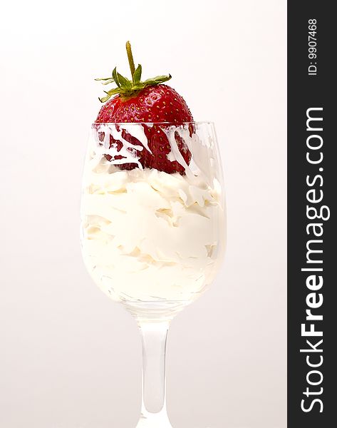 Red fresh strawberry on the whipped-cream in the glass on white. Red fresh strawberry on the whipped-cream in the glass on white