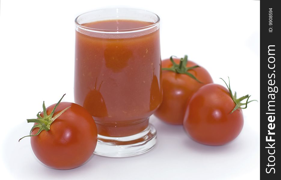 Glass of tomato juice and tomatoes on a white background