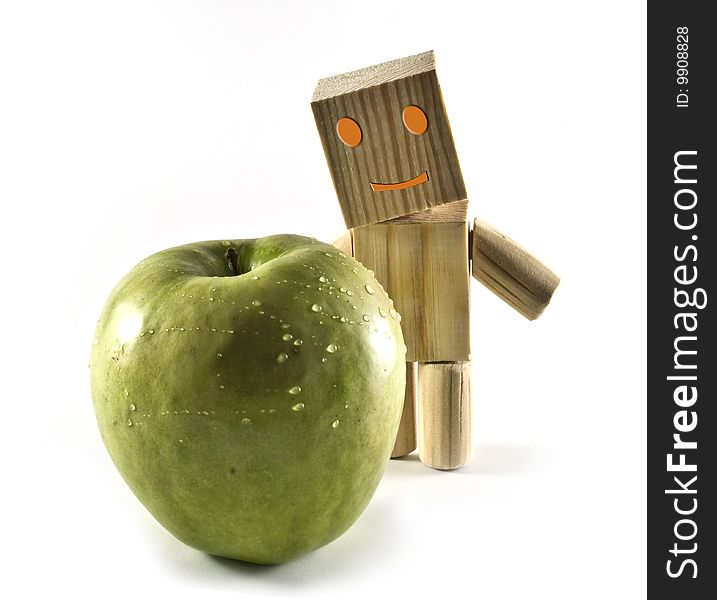 A wooden robot found a green apple. A wooden robot found a green apple