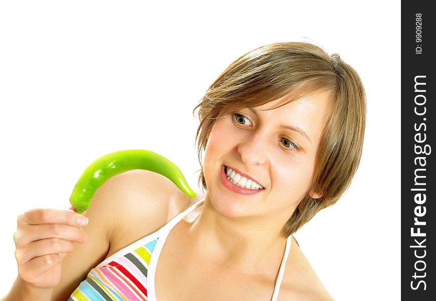 Portrait of a young cute Caucasian blond girl with a nice colorful striped summer dress who is going crazy and she is holding a fresh green chilly pepper in her hand. Isolated on white. Portrait of a young cute Caucasian blond girl with a nice colorful striped summer dress who is going crazy and she is holding a fresh green chilly pepper in her hand. Isolated on white.