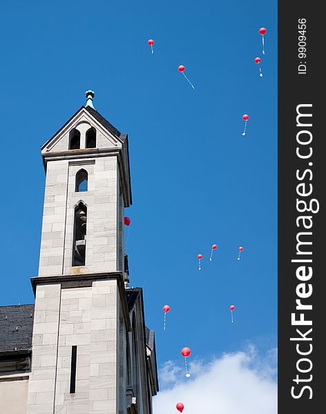 Red balloons besides church