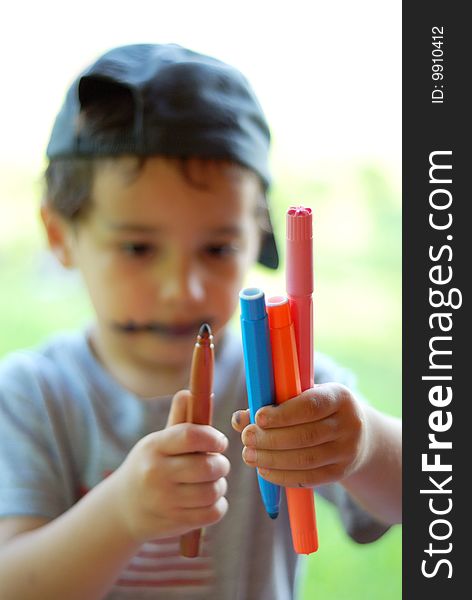 Blured boy holding color paints in his hands. Blured boy holding color paints in his hands