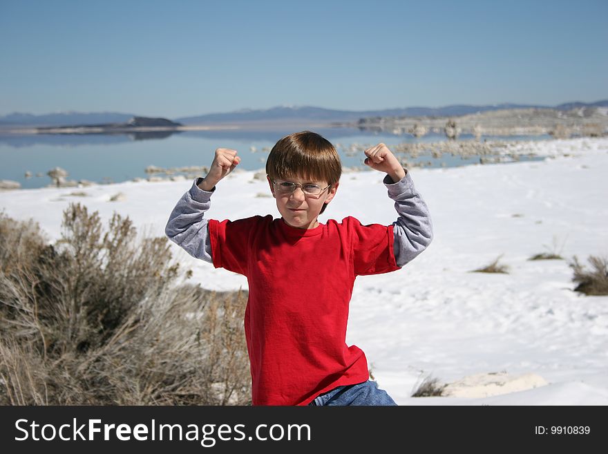 Boy showing his muscles in front of the Lake. Boy showing his muscles in front of the Lake