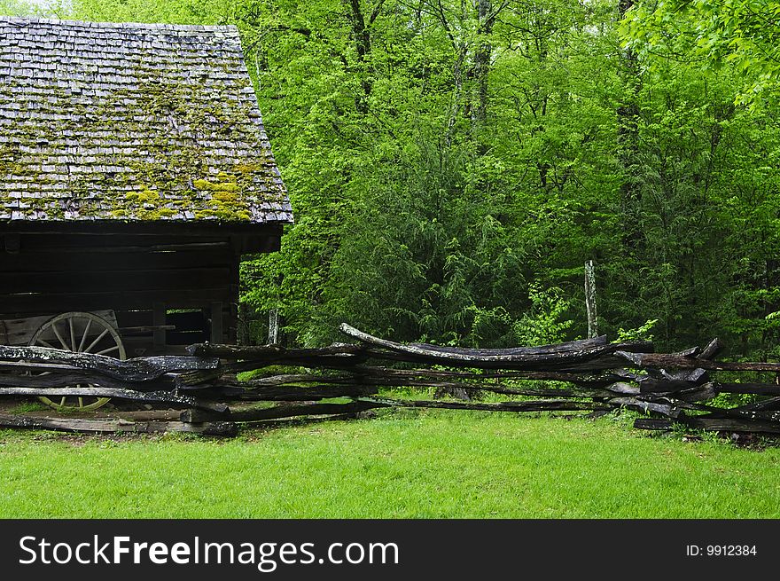 Barn in green forest with wagon and fence. Barn in green forest with wagon and fence