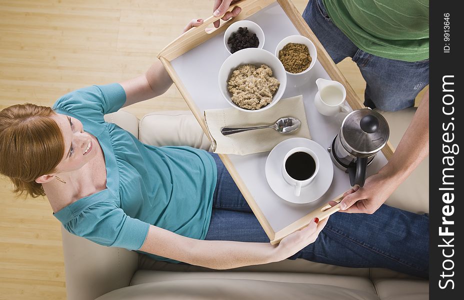 Woman Being Served Breakfast On The Couch.