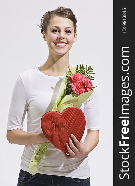 Attractive woman with flowers and heart-shaped candy box. Vertically framed shot. Attractive woman with flowers and heart-shaped candy box. Vertically framed shot.