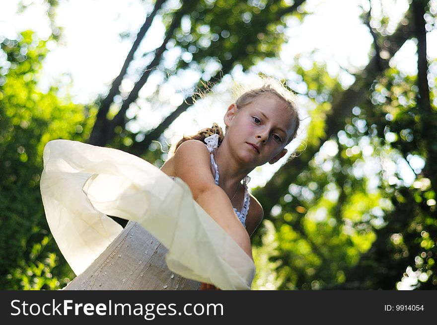 The girl in a beautiful dress poses against the nature