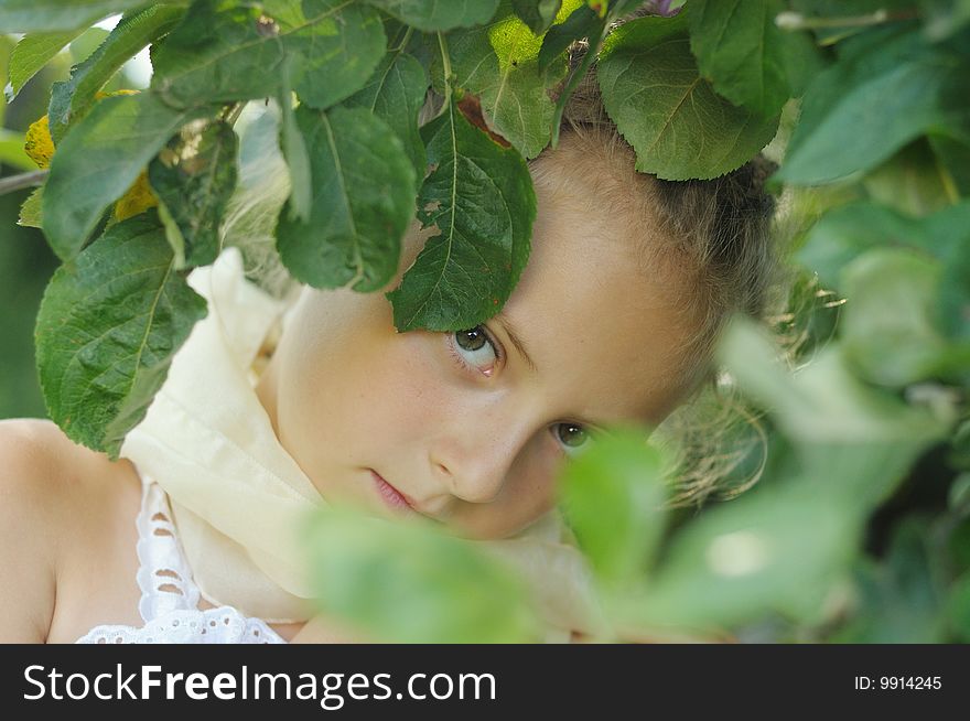 The girl looks out because of summer foliage. The girl looks out because of summer foliage
