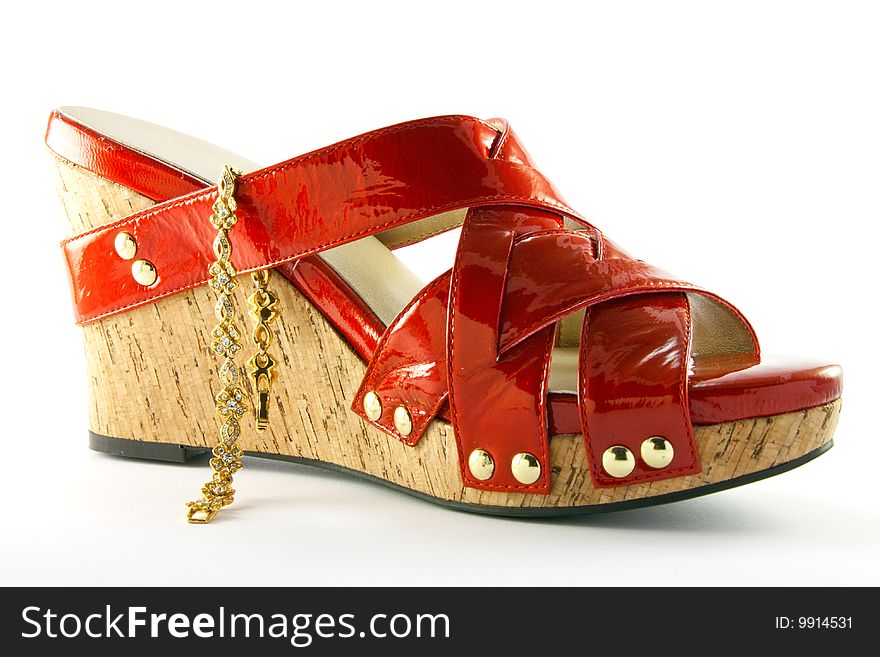 Single red shoe and gold bracelet with clipping path on a white background. Single red shoe and gold bracelet with clipping path on a white background