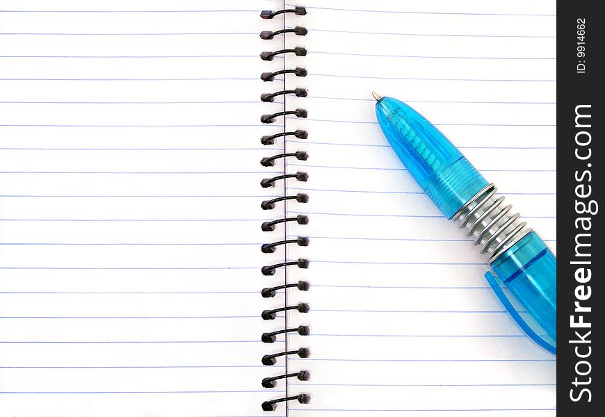A blue pen on an empty open notepad. A blue pen on an empty open notepad.