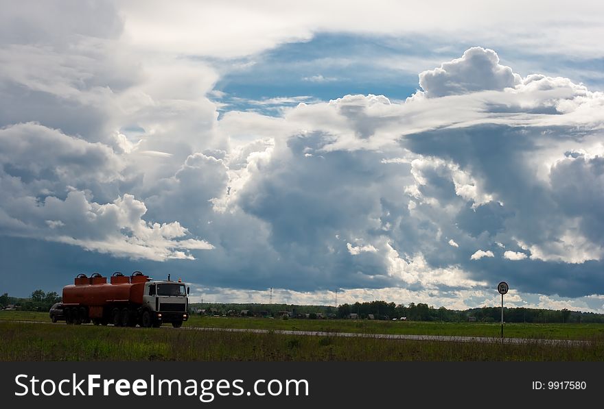 Tank truck on road and cloudy sky