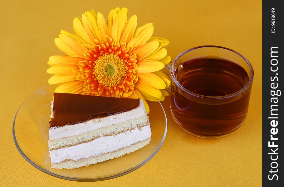 Cake with caramel on a yellow background and cup tea. Cake with caramel on a yellow background and cup tea