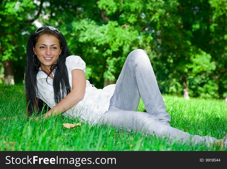 Beautiful girl laying on the green grass