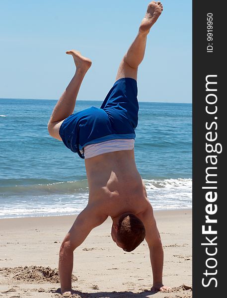 Man standing on his arms at the beach. Man standing on his arms at the beach