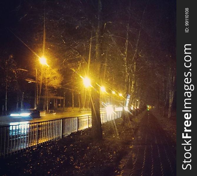 A quiet night street next to a pedestrian pathway. A quiet night street next to a pedestrian pathway.