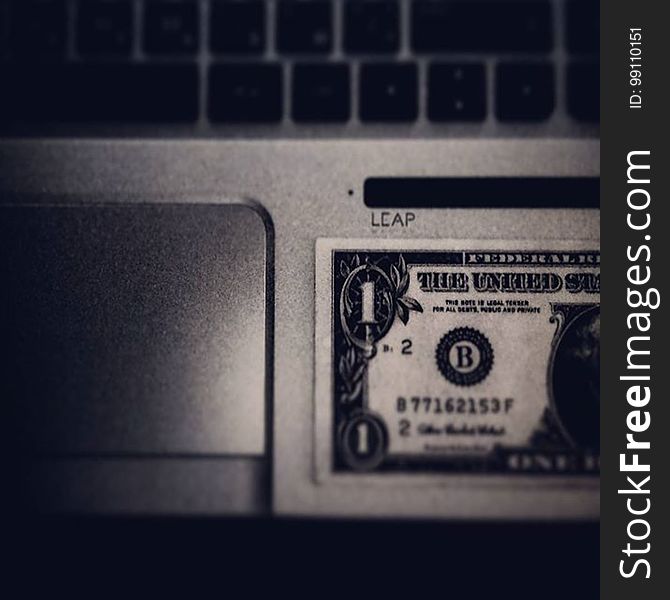 A dollar bill on a laptop keyboard. A dollar bill on a laptop keyboard.