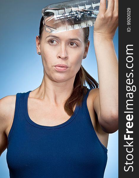 A woman cooling down with a cold water bottle on the forehead.