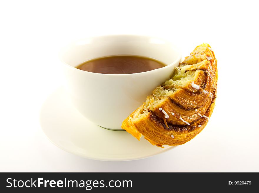 Half a cinnamon bun and cup of tea with clipping path on a white background. Half a cinnamon bun and cup of tea with clipping path on a white background