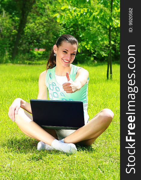 Young woman on a nature with the laptop