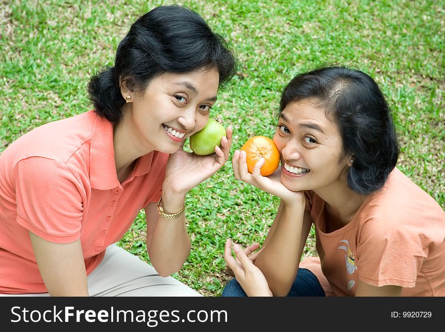 Family relationship concept: two cheerful asian sisters having fun together in the garden. Family relationship concept: two cheerful asian sisters having fun together in the garden