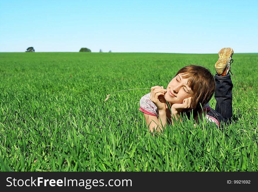 Young woman lying in green grass