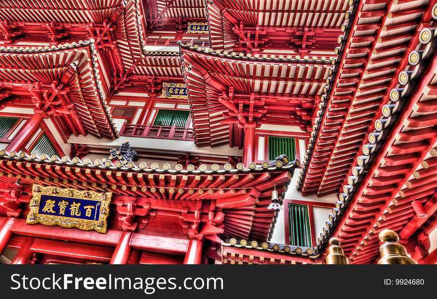 The facade of and entrance to a Buddhist temple in Chinese architectural style, in Chinatown, Singapore, from a low, look up perspective. The facade of and entrance to a Buddhist temple in Chinese architectural style, in Chinatown, Singapore, from a low, look up perspective