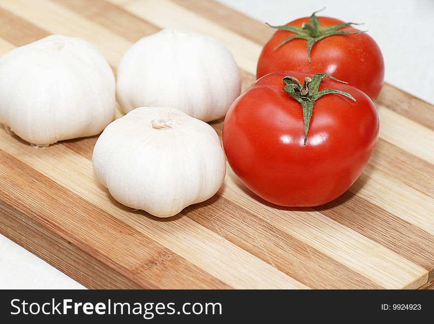 Fresh tomatoes and garlic on a chopping board